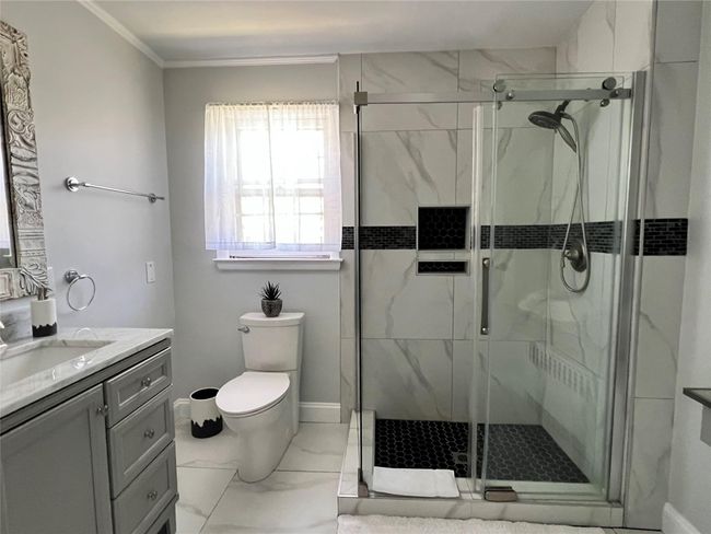 Full bath featuring marble finish floor, a stall shower, vanity, and toilet | Image 44