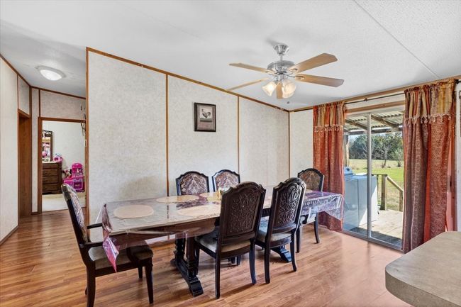 Dining room with light wood-style floors, washer / dryer, ornamental molding, and ceiling fan | Image 6