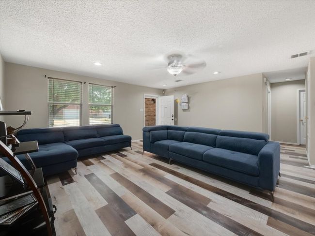 Living room featuring ceiling fan, a textured ceiling, and light wood-type flooring | Image 5