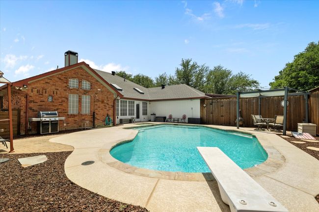View of pool with a patio, a fenced backyard, a diving board, and grilling area | Image 30