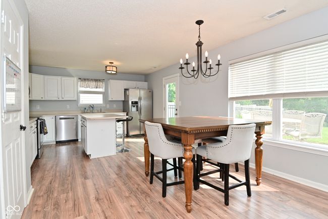 dining area with light wood-type flooring, a chandelier, and baseboards | Image 15
