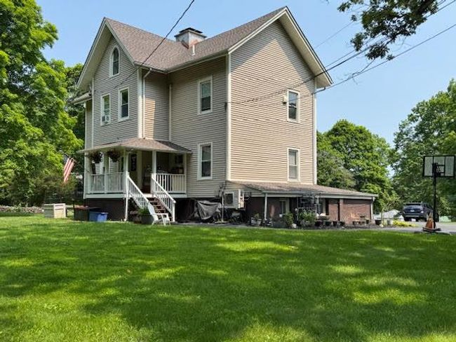 Back of house featuring covered porch and a yard | Image 37