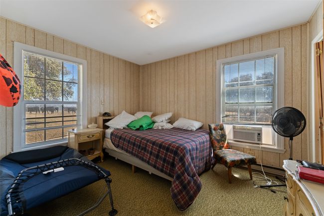 Carpeted bedroom with cooling unit, multiple windows, and wood walls | Image 14