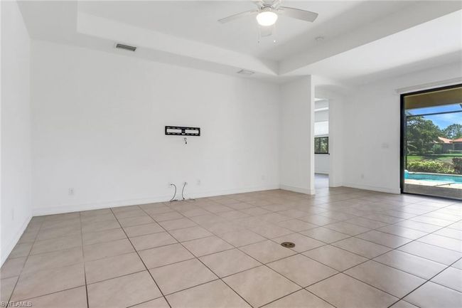 Spare room featuring a raised ceiling, ceiling fan, light tile patterned floors, and baseboards | Image 18