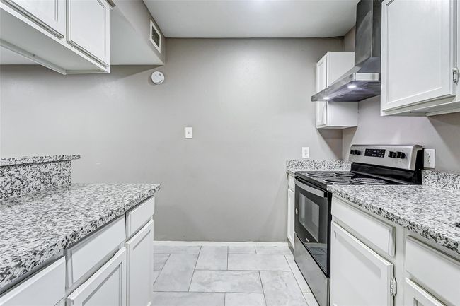 The functional and stylish kitchen design includes updated cabinetry and a modern backsplash, enhancing its charm. The granite countertops tie the space together, offering durability and a polished finish. This inviting kitchen is ready to inspire your next culinary masterpiece. | Image 9