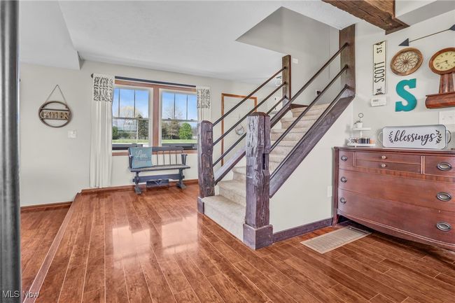Staircase featuring baseboards and wood finished floors | Image 8