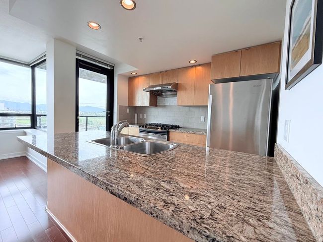Kitchen with appliances with stainless steel finishes, backsplash, stone countertops, recessed lighting, and wall chimney range hood | Image 7