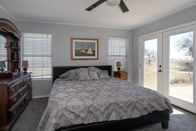 Carpeted bedroom featuring access to exterior, crown molding, french doors, baseboards, and a ceiling fan | Image 19