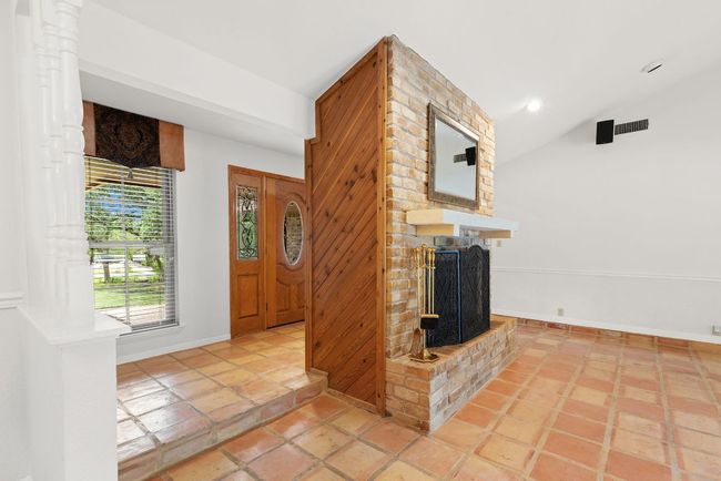 Entrance foyer featuring a brick fireplace, lofted ceiling, and recessed lighting | Image 13
