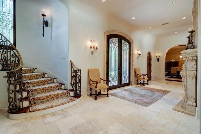 Grand Foyer has double sided limestone fireplace and carved mantel, Cantera doors, antique Mexican door and closet. Most of the home has Venetian Plaster on the walls and the staircase has Starks Carpets. There is second staircase located off the kitchen area. | Image 3