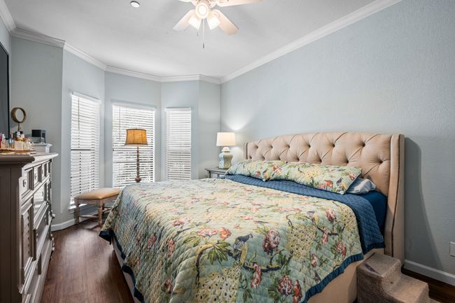 Bedroom featuring dark wood finished floors, crown molding, and ceiling fan | Image 14