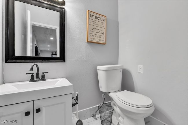 Half bathroom with toilet, marble finish floor, vanity, and baseboards | Image 22