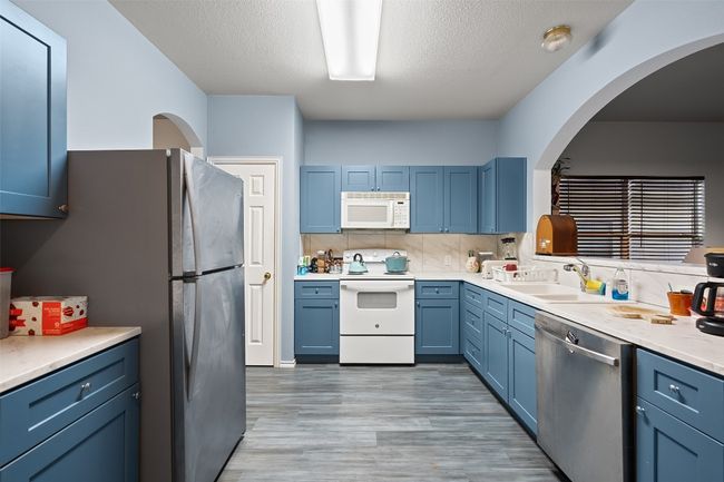 The heart of the home is a beautiful kitchen with wrap around counters, custom cabinet color, electric stove, microwave, and recent refrigerator with is included. | Image 10