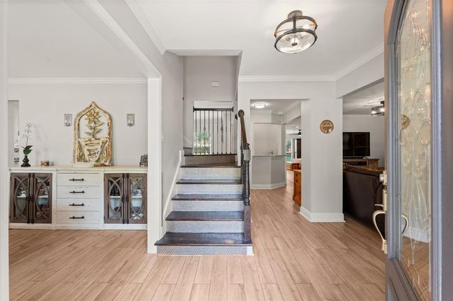 This inviting home entry features a bright, open foyer. To the left is the formal dining room, and to the right extends into the spacious living area. | Image 4