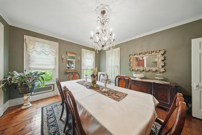 Dining room featuring a chandelier, wood-type flooring, crown molding, and baseboards | Image 19