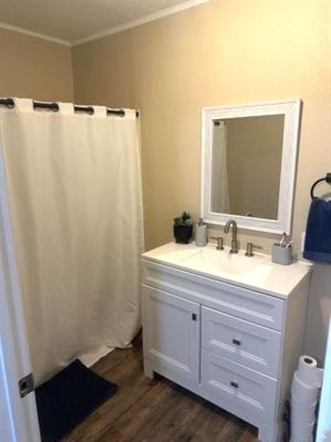 Bathroom with crown molding, wood finished floors, and vanity | Image 14