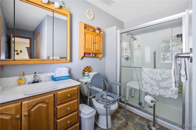Full bath with a shower stall, visible vents, toilet, and vanity | Image 11