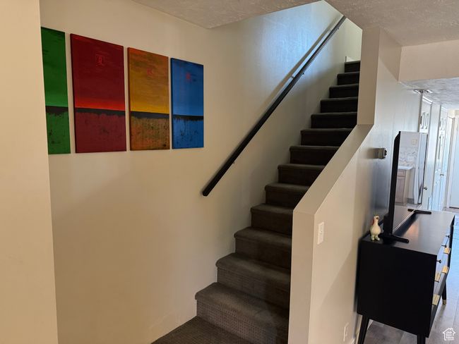 Stairway featuring a textured ceiling | Image 24