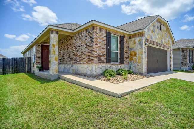 View of front of house with driveway, a garage, a shingled roof, and stone siding | Image 11