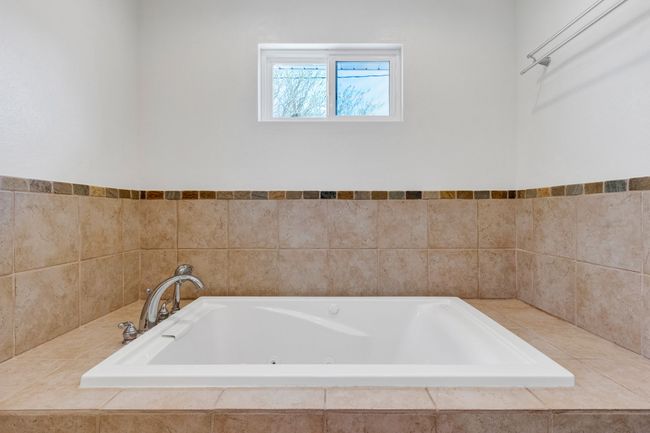 Full bath featuring tile patterned flooring, vanity, and a baseboard radiator | Image 17