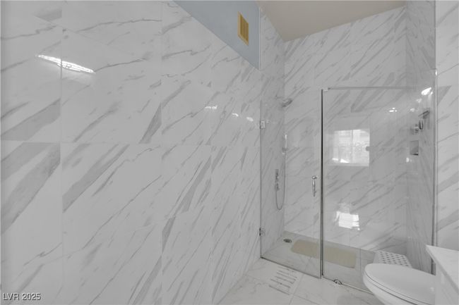 Bathroom featuring a marble finish shower, marble finish flooring, and vanity | Image 33
