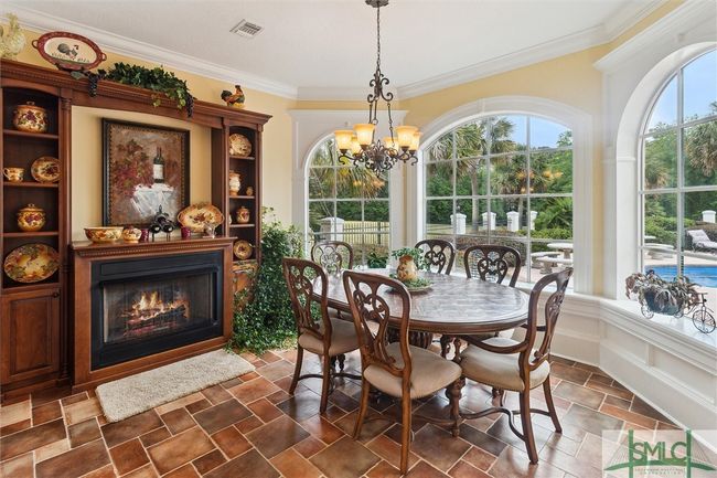 A second gas fireplace keeps the cozy area toasty on cool mornings. Bay windows showcase the pool area. | Image 15