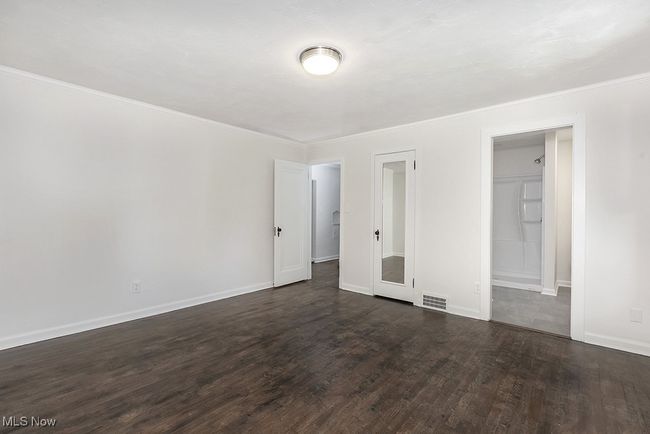 Unfurnished bedroom with a closet and dark hardwood / wood-style floors | Image 24
