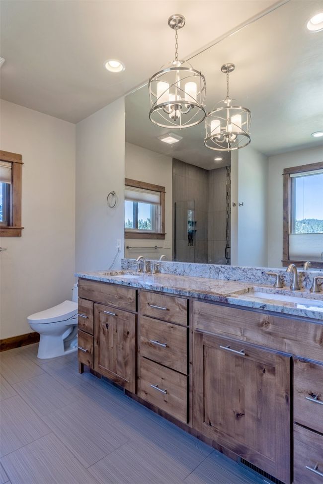 Full bathroom with a chandelier, double vanity, toilet, baseboards, and recessed lighting | Image 18