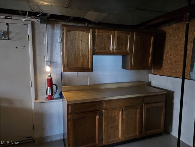 Kitchen with light countertops and concrete block wall | Image 10