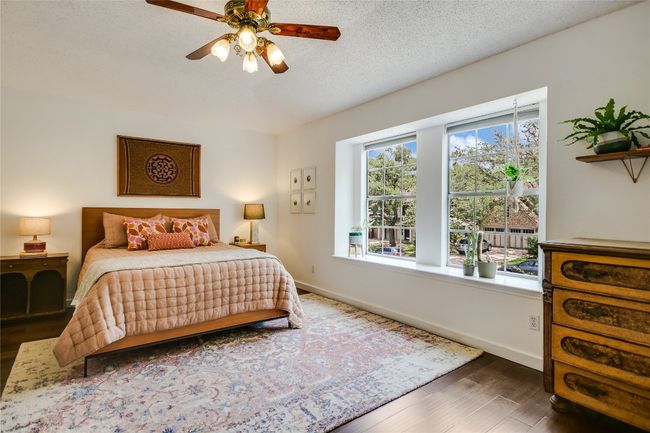 Primary bedroom with hardwood flooring is very spacious and comfortable. | Image 12