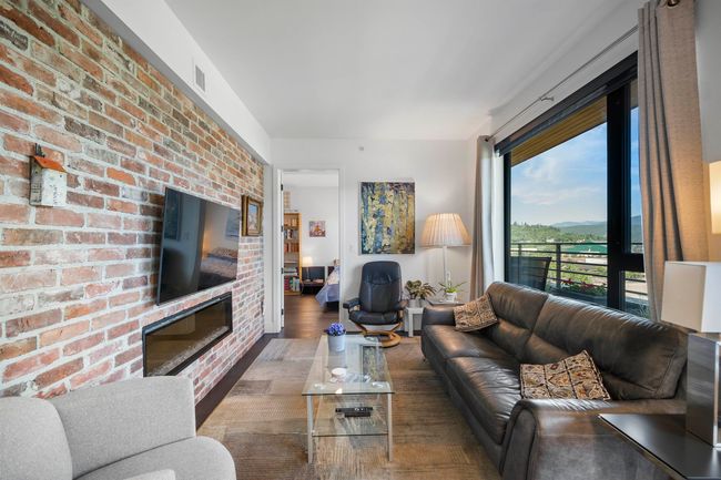 Living area with wood finished floors and brick wall | Image 10