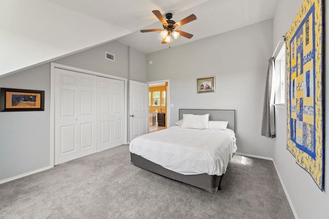 Carpeted bedroom with a closet, a ceiling fan, lofted ceiling, baseboards, and visible vents | Image 20