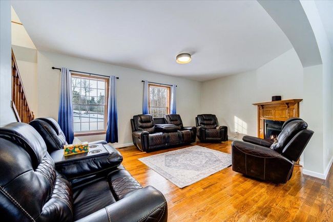 Living room with stairs, a lit fireplace, arched walkways, wood finished floors | Image 19