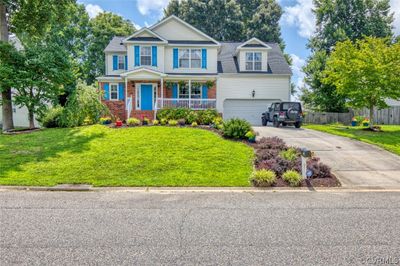 View of front facade with a garage, covered porch, and a front lawn | Image 1