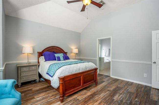 This view of the primary bedroom offers a glimpse into the en suite bath, showcasing the seamless flow and thoughtful layout of this serene retreat. | Image 18