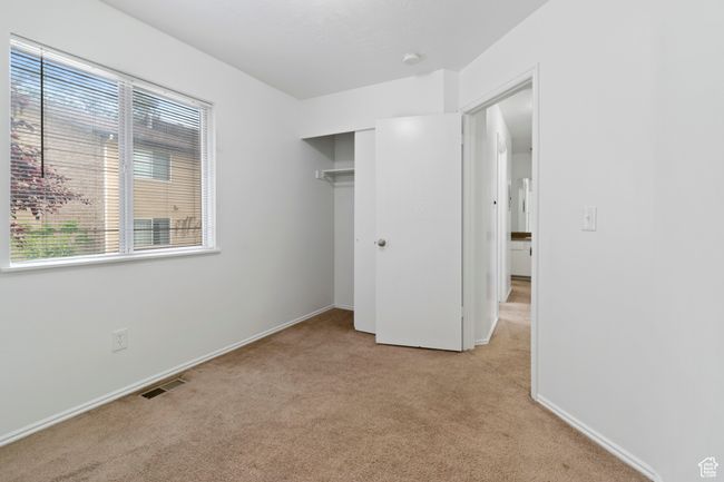 Unfurnished bedroom featuring light carpet, multiple windows, and a closet | Image 24