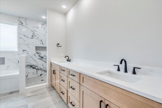 Bathroom with a marble finish shower, double vanity, a bath, recessed lighting, and tile patterned floors | Image 18
