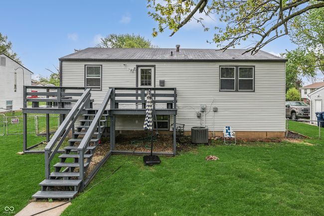 rear view of house featuring a wooden deck, stairway, a yard, cooling unit, and fence | Image 26