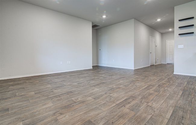Unfurnished room with wood finished floors, baseboards, visible vents, and recessed lighting | Image 11