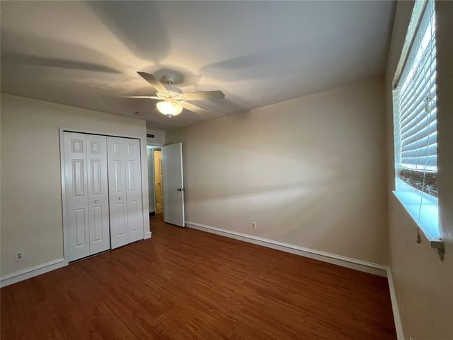 Unfurnished bedroom with baseboards, wood finished floors, and a ceiling fan | Image 22