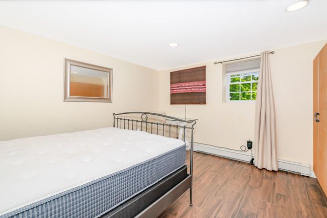 Bedroom with wood finished floors, recessed lighting, and a baseboard heating unit | Image 9