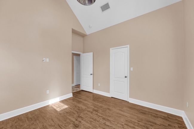 Empty room with high vaulted ceiling and wood finished floors | Image 25