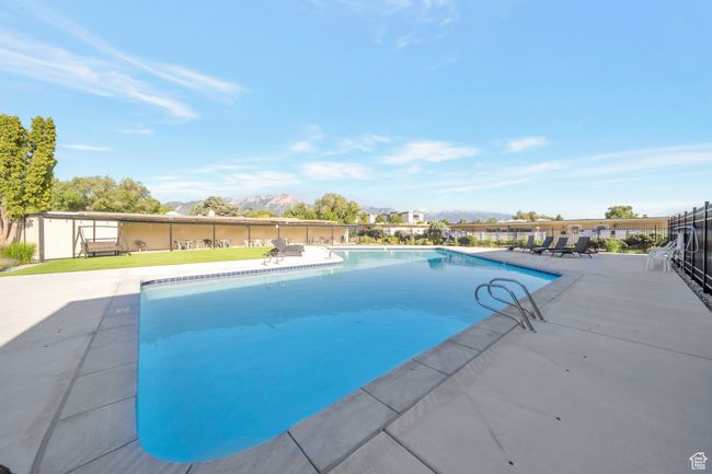 View of swimming pool with a mountain view and a patio area | Image 17