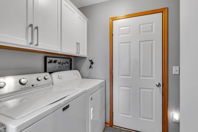 Admire this finished laundry room with storage off of the garage. | Image 16