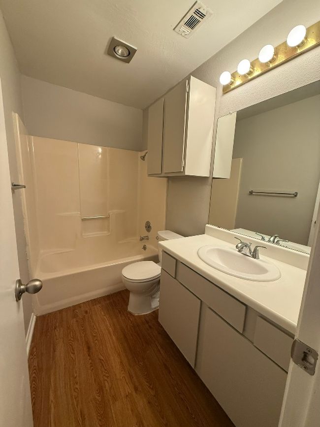 Bathroom featuring wood finished floors, vanity, and washtub / shower combination | Image 12