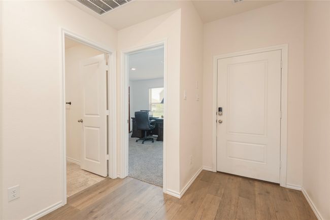Corridor with an office area and light wood-style flooring | Image 5