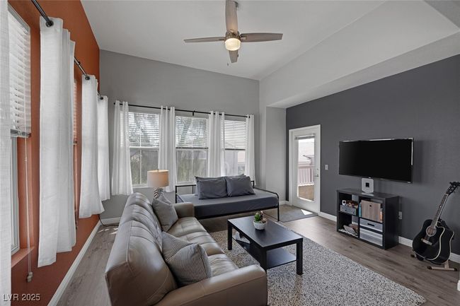 Living area featuring baseboards, ceiling fan, wood finished floors, and a wealth of natural light | Image 16