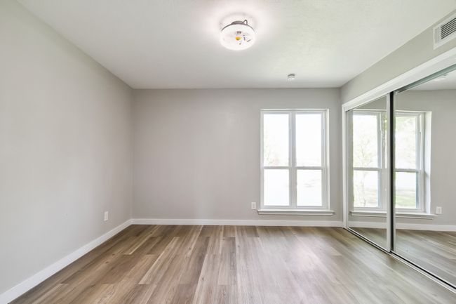 Spare room featuring a wealth of natural light, wood finished floors, visible vents, and baseboards | Image 21