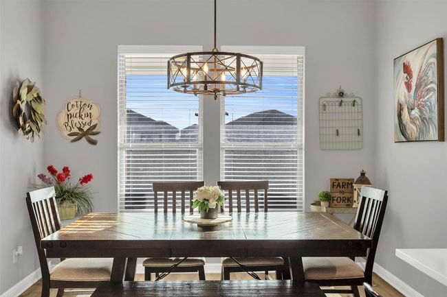 Dining space with baseboards, plenty of natural light, and a notable chandelier | Image 12