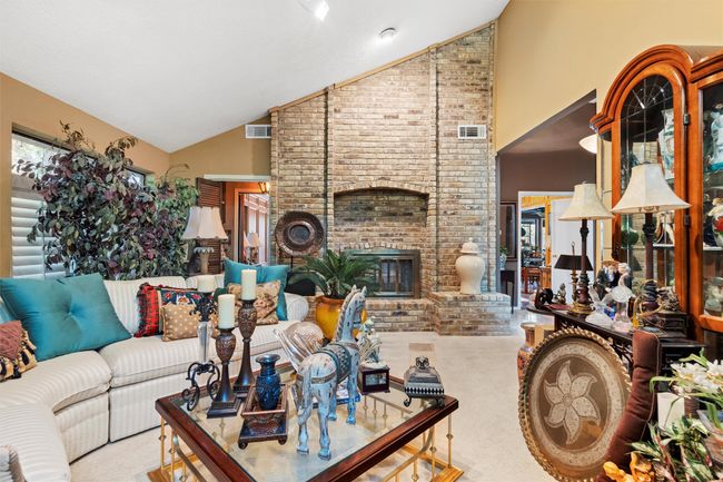 Living area with high vaulted ceiling, visible vents, and carpet | Image 11
